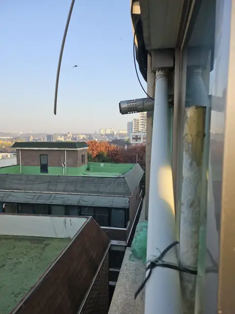 옥상 난간 옆 녹색 얼룩이 남은 우수관 연결부, 우수관부분교체 전
